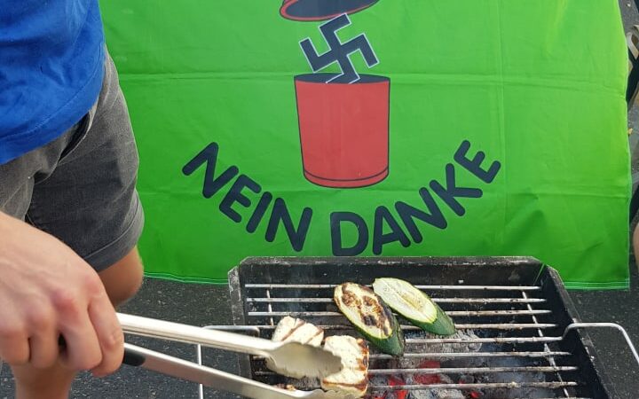 Person beim Grillen vor einer "Nazis? Nein Danke!" fahne