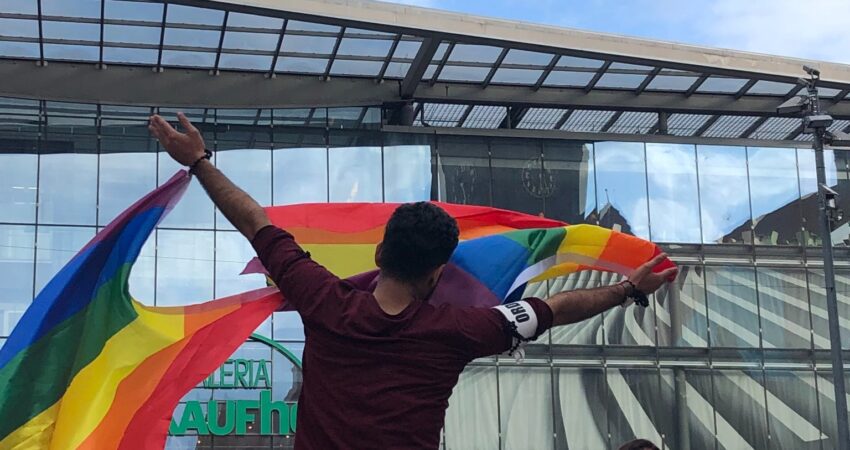Person schwenkt Regenbogenflagge