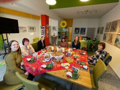 6 Frauen sitzen um einen weihnachtlich gedeckten Tisch